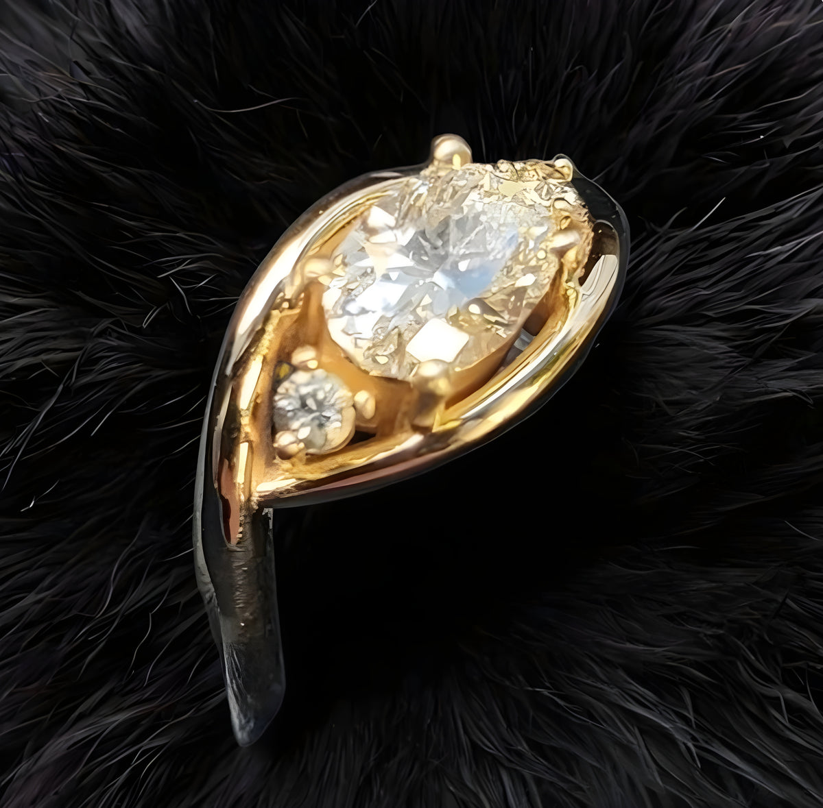 Gold and silver ring with a large central gemstone on a black fur background