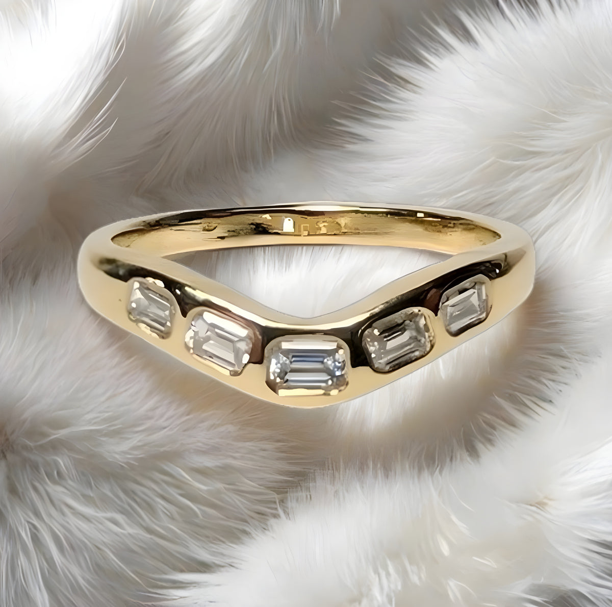 Gold ring with diamond accents on a white fur background